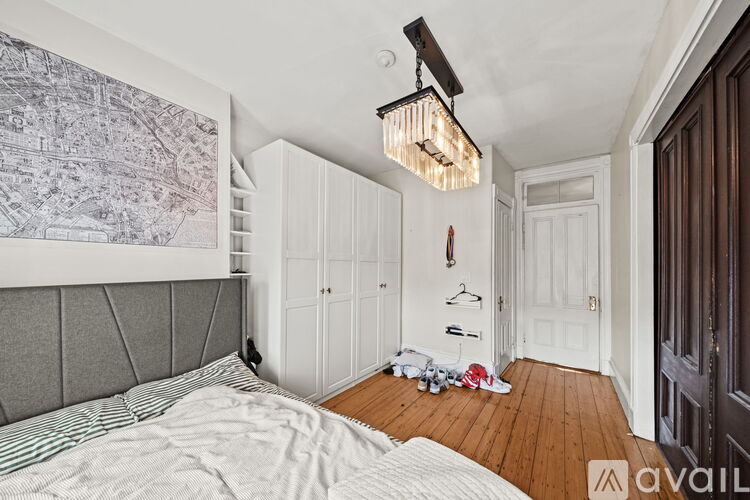 A bedroom with a large bed and a wooden floor.