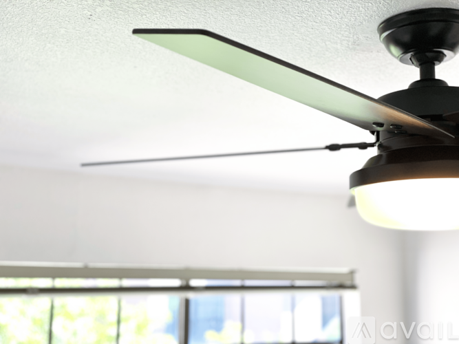 A ceiling fan with a light fixture is mounted in a room.