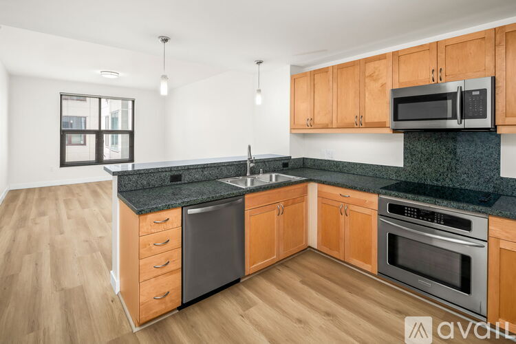A kitchen with wooden cabinets and black countertops.