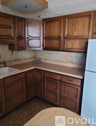 A kitchen with wooden cabinets and a white refrigerator.