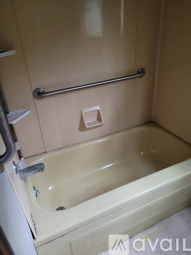 A bathroom with a bathtub and a towel rack.