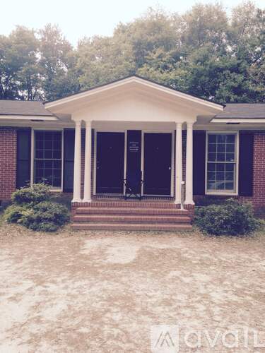 A brick house with a porch and a covered front door.