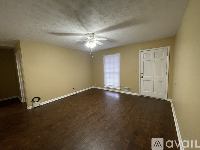 A room with a ceiling fan and a wall-mounted air conditioning unit.