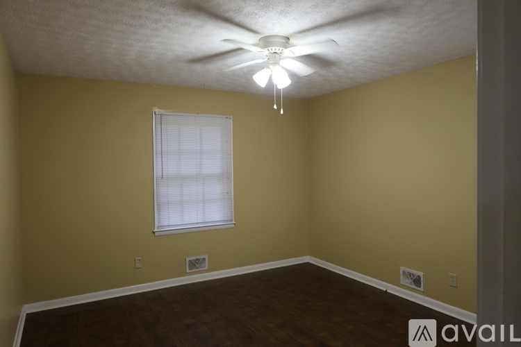 A room with a ceiling fan and a window.