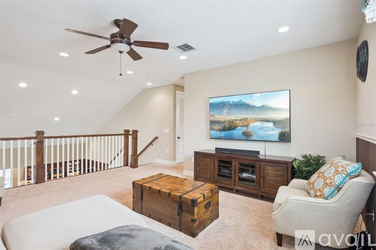 A living room with a large painting on the wall and a ceiling fan.