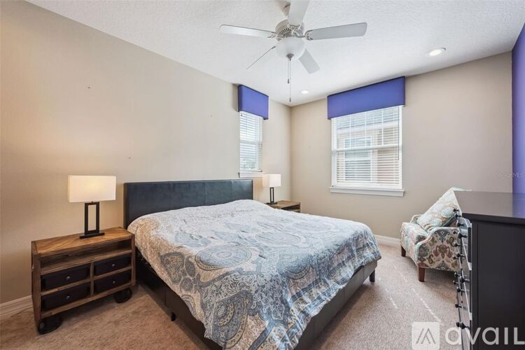 A bedroom with a large bed and a ceiling fan.