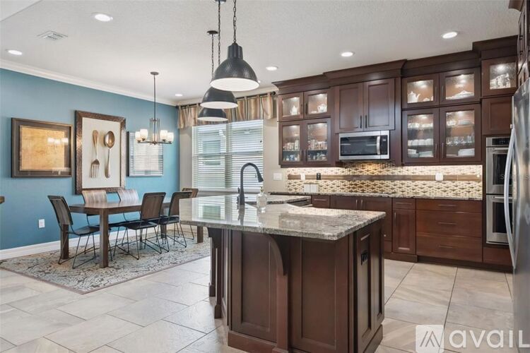 A kitchen with brown cabinets and a granite countertop.