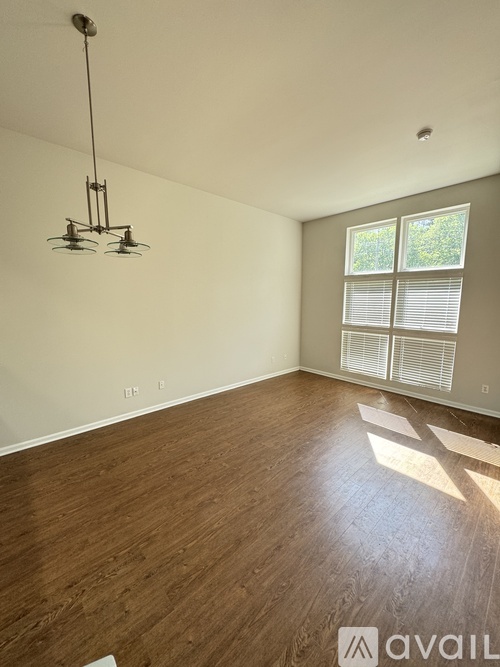 A room with wooden floors and a hanging light fixture.