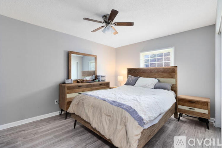 A bedroom with a bed, nightstand, and mirror.