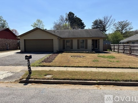 A house with a garage and a mailbox in front of it.