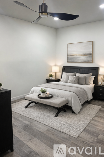 A bedroom with a bed, nightstand, and a ceiling fan.