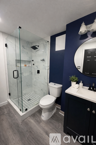 A bathroom with a toilet, sink, and shower.