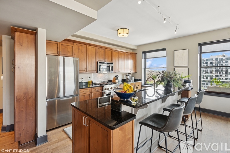 A kitchen with wooden cabinets and a stainless steel refrigerator.