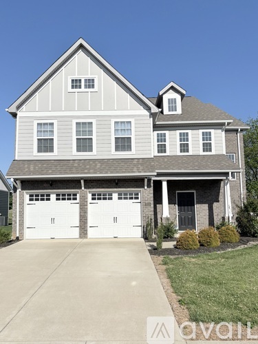A two-story house with a garage is for sale.