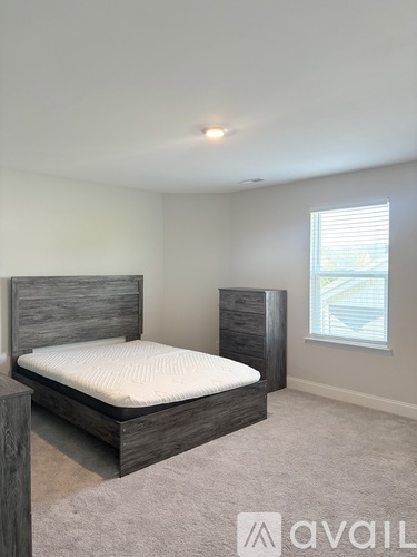 A bedroom with a large bed and a window.