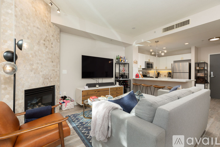 A living room with a grey couch and a fireplace.