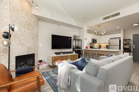A living room with a grey couch and a fireplace.