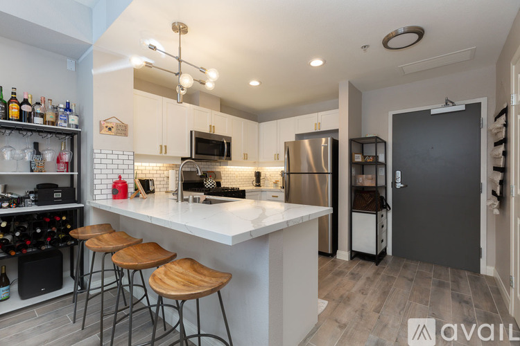A kitchen with a white countertop and wooden bar stools.