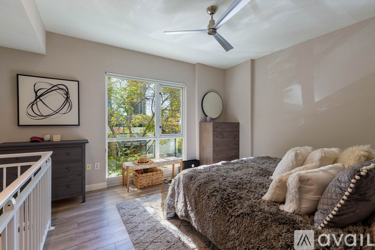 A bedroom with a large bed and a painting on the wall.