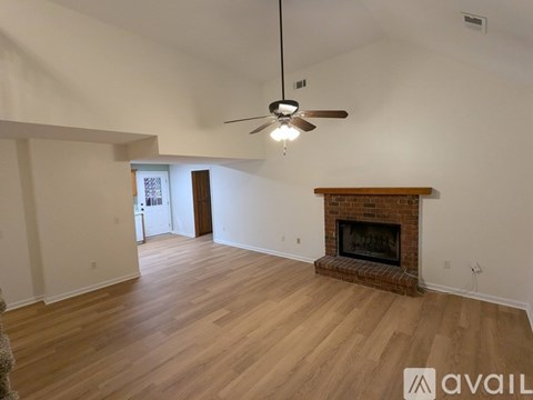 A room with a fireplace and a ceiling fan.