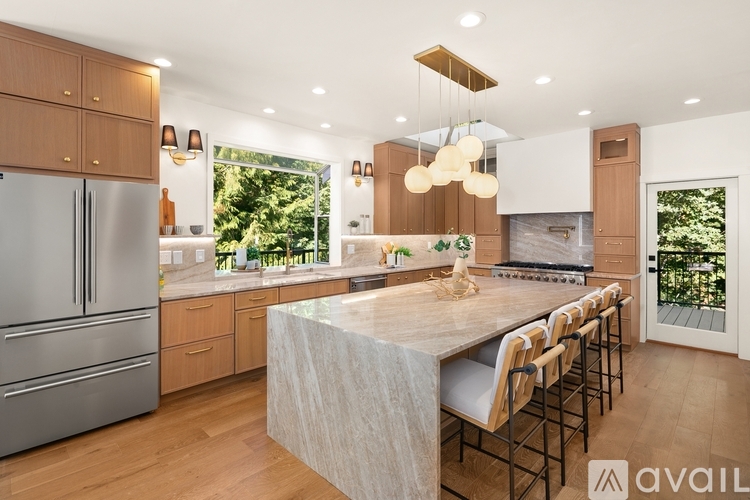 A modern kitchen with wooden cabinets and a marble island.