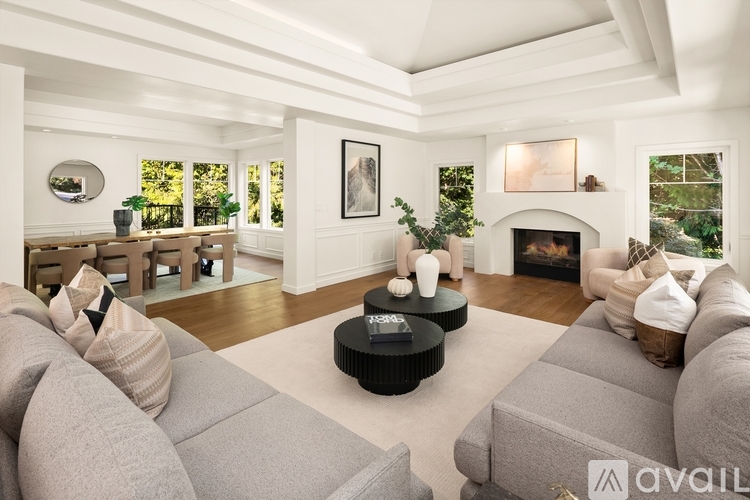 A living room with a grey couch and a fireplace.