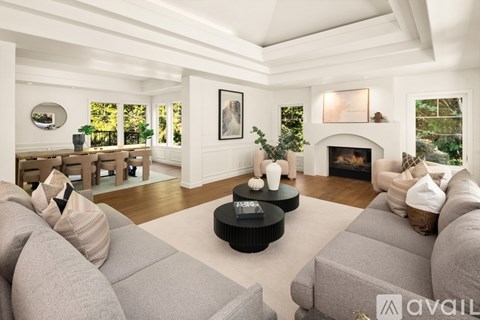 A living room with a grey couch and a fireplace.