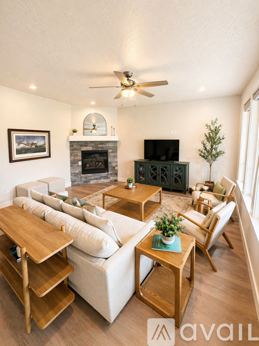 A living room with a white couch, a wooden coffee table, and a fireplace.