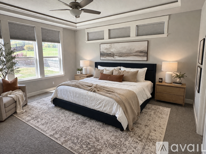 A bedroom with a large bed and a ceiling fan.