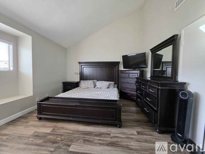 A bedroom with a bed, dresser, and mirror.