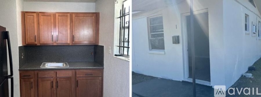 A kitchen with wooden cabinets and a black fridge.