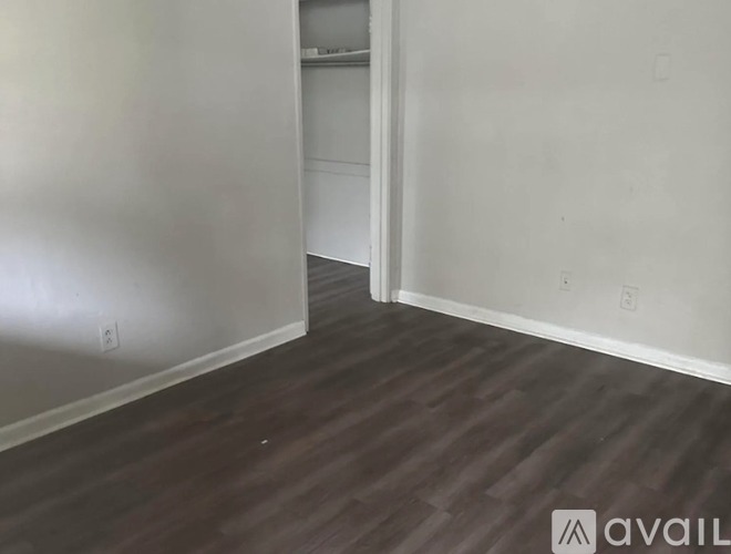 A room with wooden flooring and white walls.