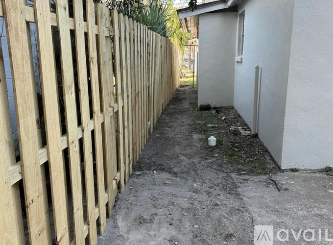 A wooden fence runs along the side of a building.