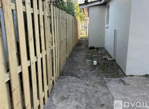 A wooden fence runs along the side of a building.