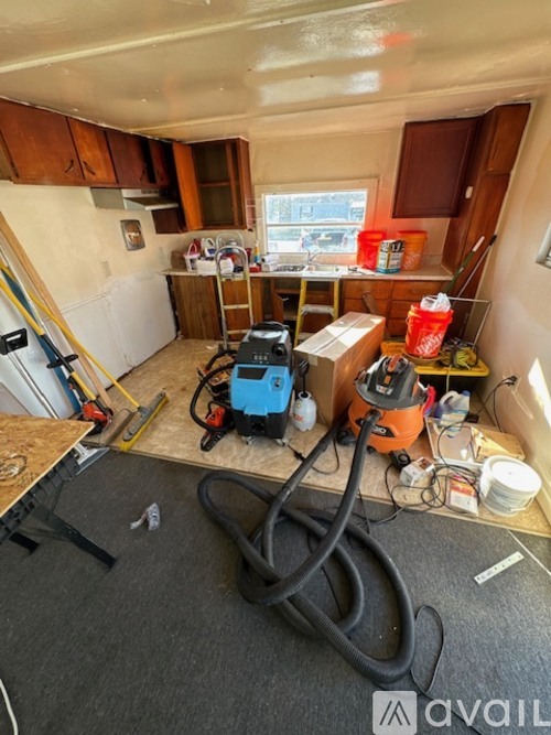 A room with a blue and black vacuum cleaner on the floor.