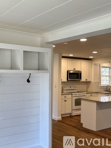 A kitchen with white cabinets and a white wall.