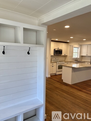 A kitchen with white cabinets and a wooden floor.