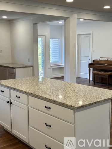A kitchen with granite countertops and white cabinets.
