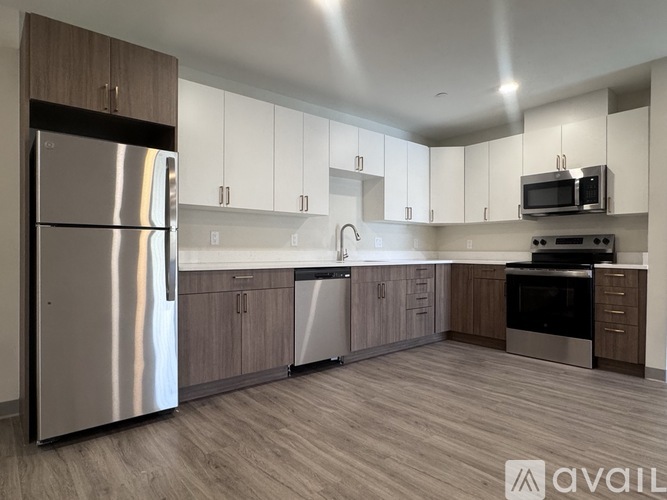 A modern kitchen with a stainless steel refrigerator and wooden cabinets.