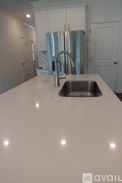A kitchen with a sink and a refrigerator.