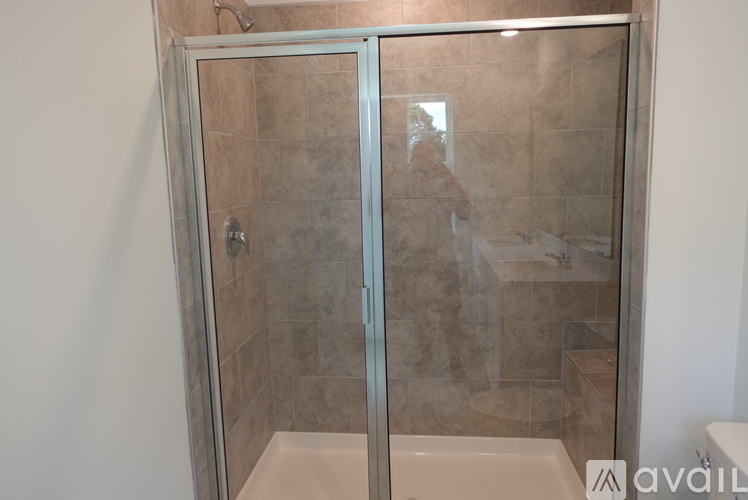 A person is taking a shower in a tiled bathroom.