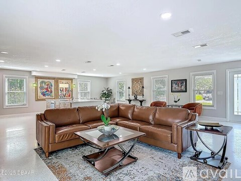A living room with a brown leather couch and a coffee table.