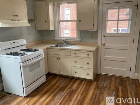 A kitchen with a white stove and cabinets.