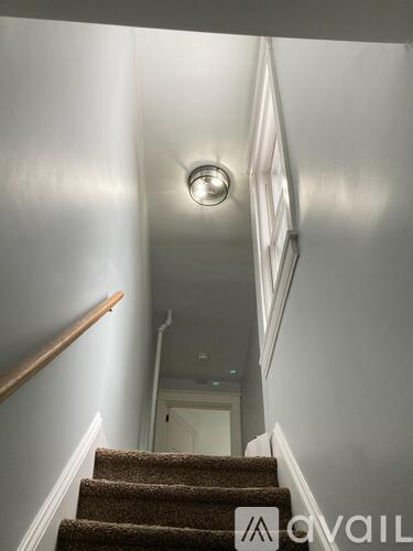 A staircase with a light on the wall.