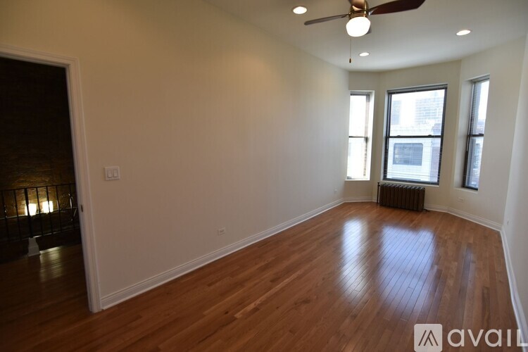 A room with wooden floors and a ceiling fan.
