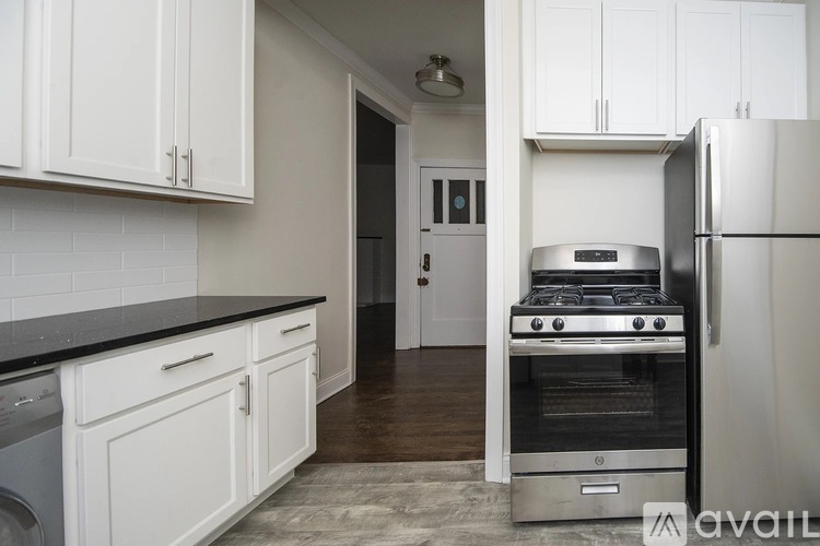 A kitchen with white cabinets and a black countertop.