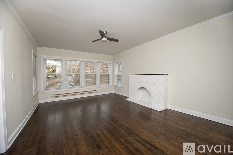 A room with a fireplace and a fan on the ceiling.