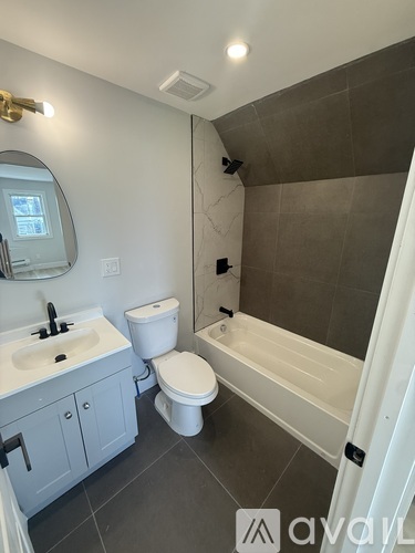 A bathroom with a toilet, sink, and bathtub.