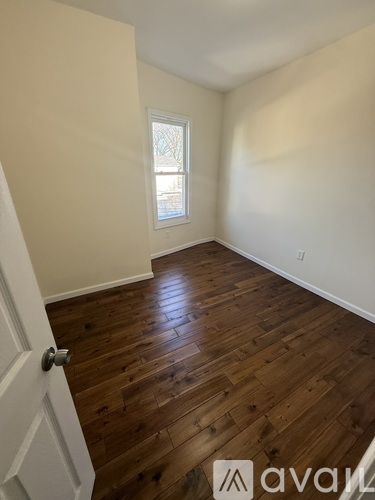 A room with wooden flooring and a white door.