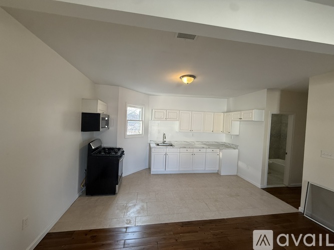 A spacious living area with a kitchen in the background.
